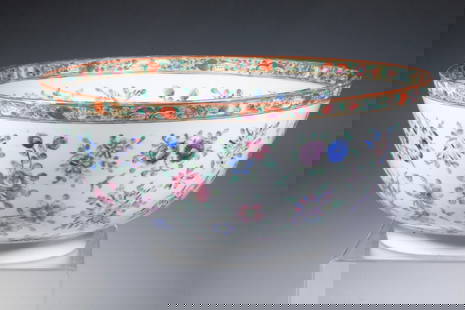LARGE CHINESE EXPORT FAMILLE ROSE PORCELAIN BOWL: A finely potted Chinese porcelain bowl with rounded sides and flat foot, decorated in vibrant famille rose enamels with dense floral sprays around the exterior and a gilt floral-and-peach border at th