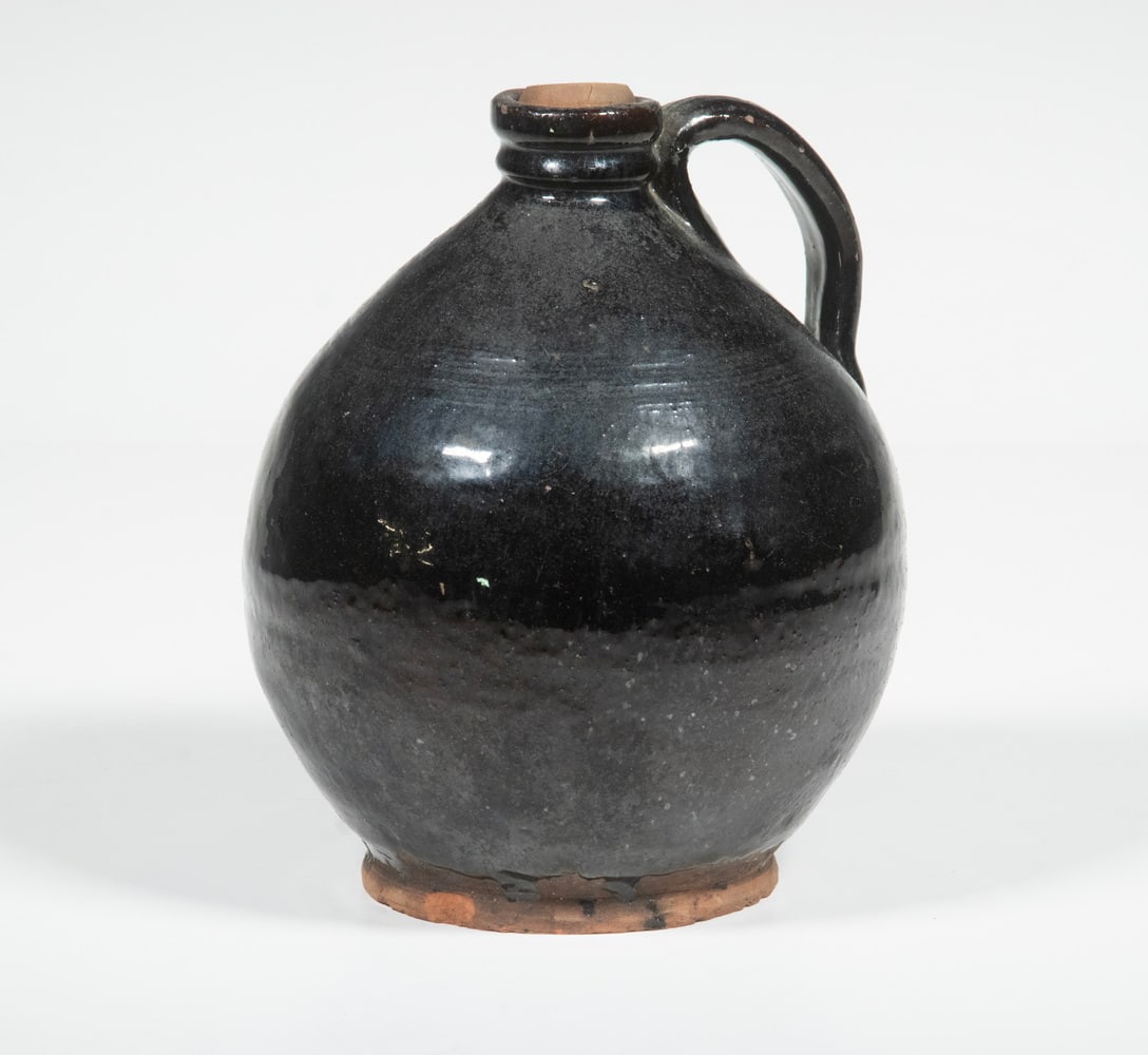 NEW ENGLAND REDWARE JUG: NEW ENGLAND REDWARE JUG 19th c. Glazed Redware Vessel, ovoid shape with five tooled shoulder lines, pronounced foot, applied handle. From the estate of Larry and Jean Dubord. Size: Height: 6 1/2 in. (