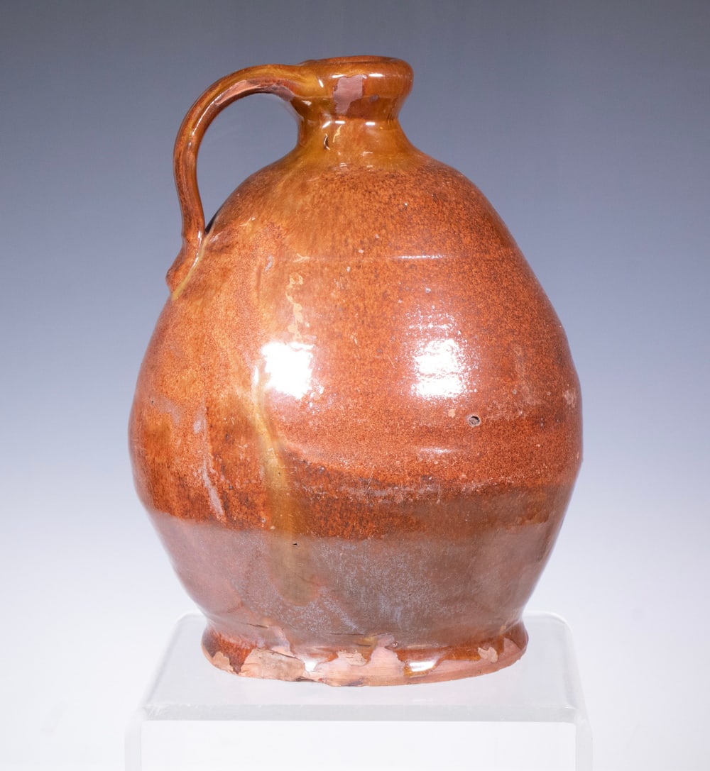 MAINE REDWARE JUG, ATTRIBUTED TO NORCROSS: MAINE REDWARE JUG, ATTRIBUTED TO NORCROSS Mid-19th c. Copper Glazed Jug, attributed to Matthias Norcross of Farmington, ME, with a tooled indentation below the shoulder, applied handle. Foot chip. Fro