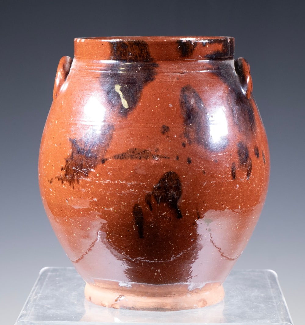 AMERICAN REDWARE HALF GALLON CROCK, 19TH CENTURY: AMERICAN REDWARE HALF GALLON CROCK, 19TH CENTURY Ovoid redware crock with squared rim and applied ear handles, covered in a thick reddish-brown lead glaze with dark manganese spotting. Likely produced