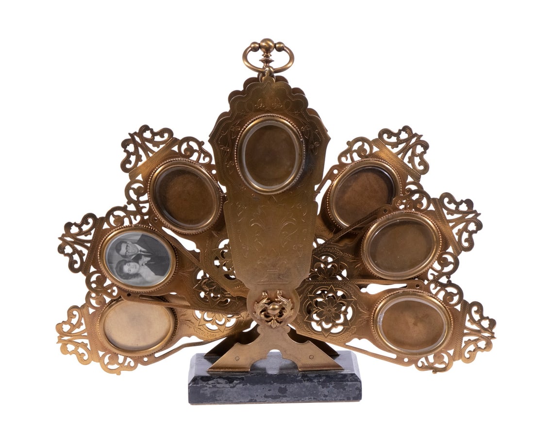 VICTORIAN BRASS FOLDING PHOTO DISPLAY: Rare 19th c. Tabletop Fan Form Holder for multiple photographs, with one stationary and six folding arms, each having an affixed oval frame with beveled glass cover, set on a black marble base. Open: 
