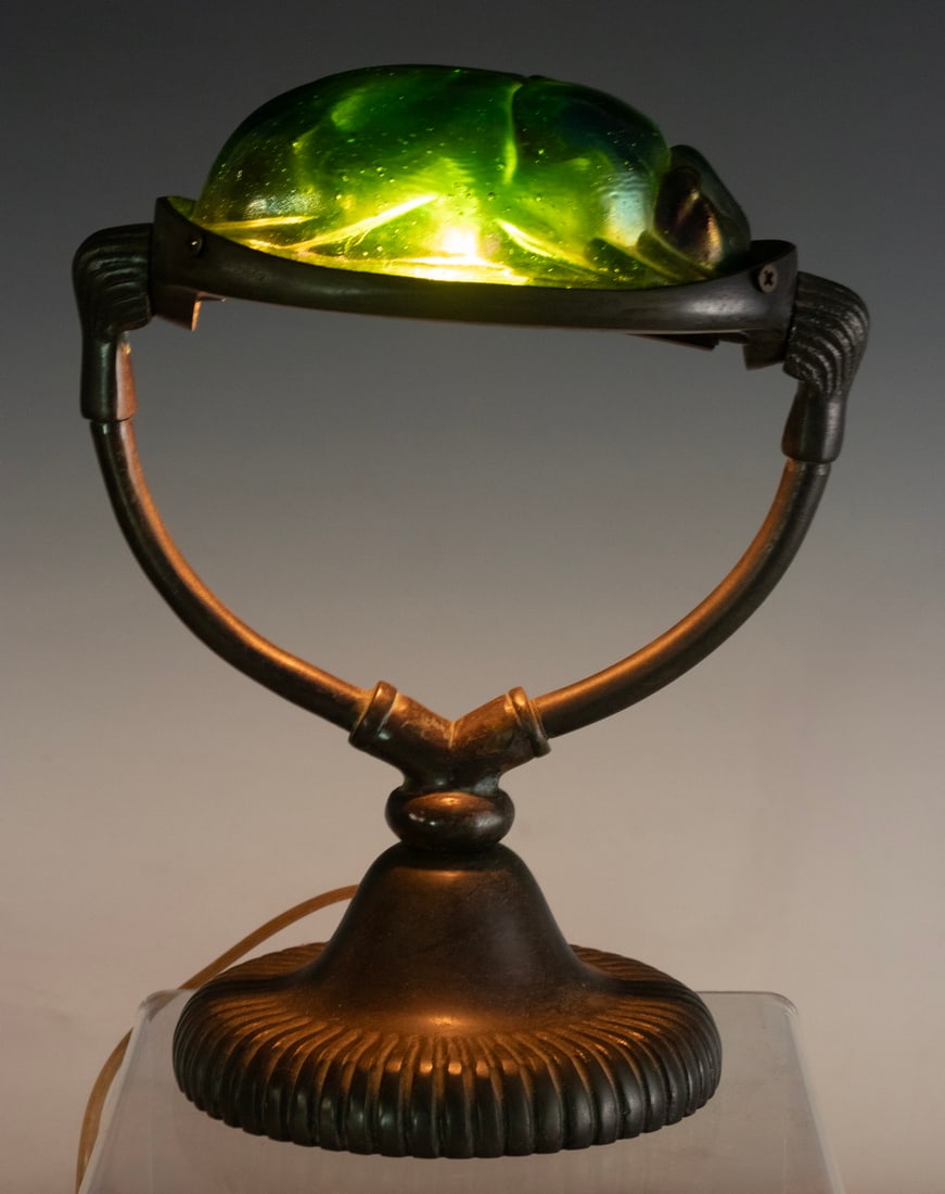 TIFFANY STYLE IRIDESCENT ART GLASS SCARAB LAMP: Early to mid-20th century, in the Art Nouveau revival style. The domed shade in the form of a scarab beetle, executed in iridescent art glass with shimmering hues of emerald, cobalt, and amethyst. Mou