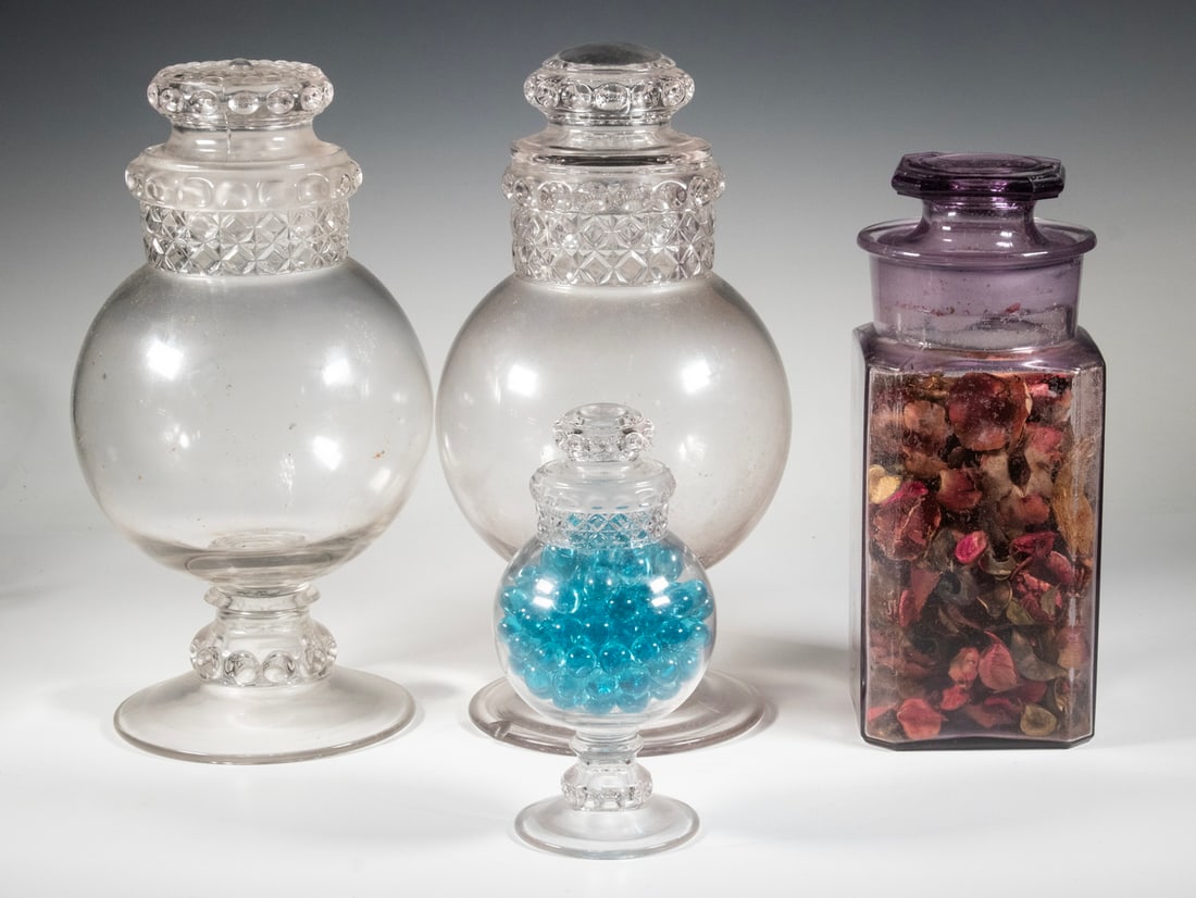 (4) GLASS APOTHECARY JARS: Group of (4) Drug Store Merchandising Jars, incl: (3) 19th c. clear lidded glass jars with bulbous bodies, molded neck and lid decoration, 7 3/4" high to 13 1/2" high. Largest with lid and foot edge c