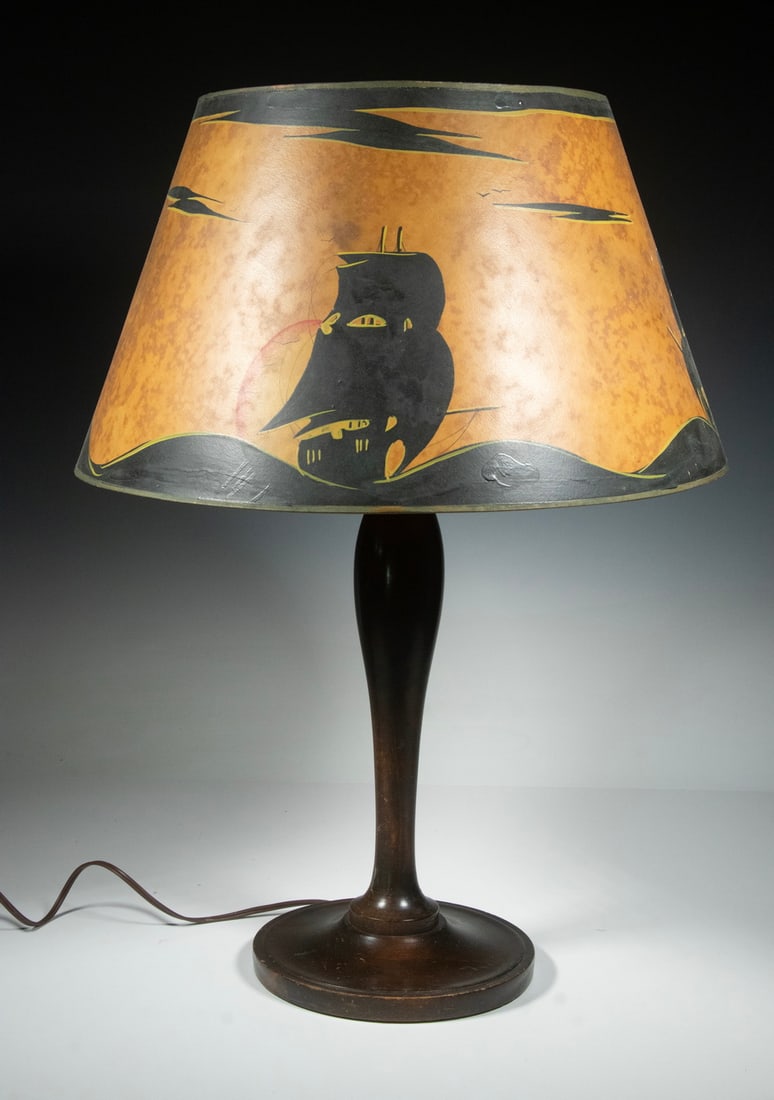 VINTAGE WOODEN TABLE LAMP WITH PAINTED SHADE: Turned Baluster Form Wooden Lamp, having a cardboard shade with black and gold painted sailing ships on rolling waves, double socket fixture with chain pull (one missing), with finial. 24 1/2 x 18 x 1