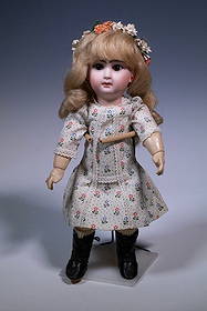 FRENCH BISQUE HEAD DOLL W/ BLONDE CURLS: Girl with flowers in her hair, brown glass eyes, white floral chintz summer dress.Back of head marked B. 4. L., indicating manufacture by Jumeau for the Louvre Department Store in Paris, c. 1890 Heigh