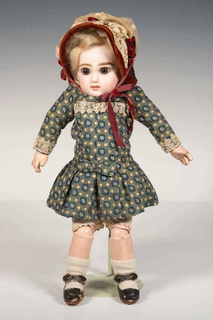 JUMEAU DOLL W/ BONNET: Blonde, with bisque head, brown glass eyes, blue and white cotton chintz, Height: 12 in. (30.5 cm.)