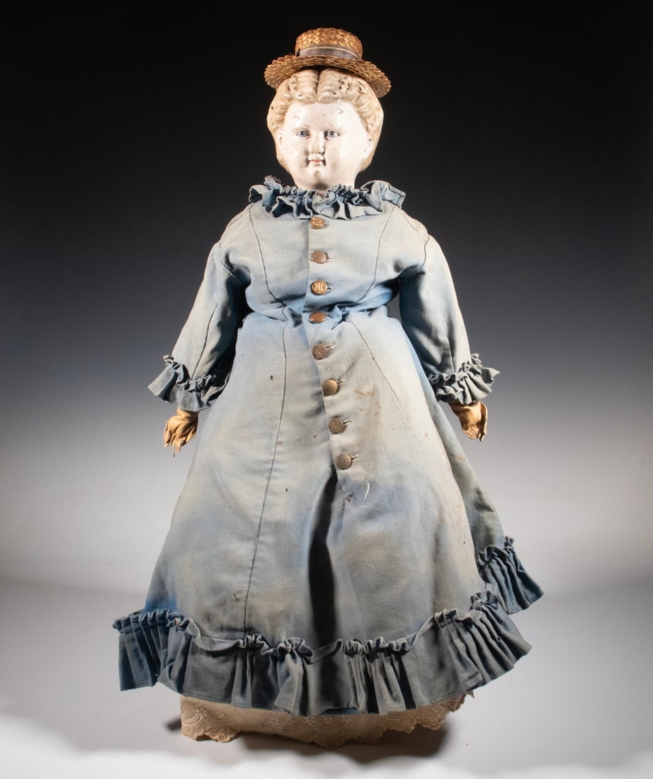 28" COMPOSITION HEAD JENNY LIND DOLL, CIRCA 1880: Painted blonde hair, blue-eyed, cloth body with kid hands, straw hat, in a lined blue travel dress with metal buttons, cotton bloomers and underskirt, black leather boots, sun-faded. OS: 30 x 10 x 5 i