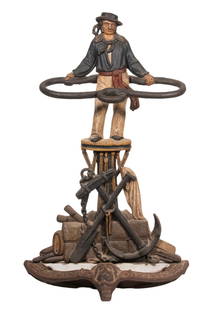 19TH C. CAST IRON JACK TAR UMBRELLA STAND: Victorian Figural Umbrella or Cane Holder, with polychrome painted surface, depicting a sailor standing atop a capstan grasping a rope, the plinth decorated with an anchor, spade, and barrels, with a