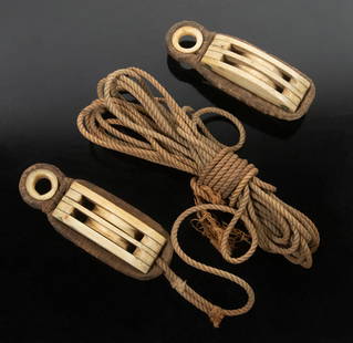 (2) WHALEBONE SHIP PULLEYS: Lot of (2) 19th c. Sailor Made Double Pulley Blocks, with copper rivets, canvas wrapped strops, one with attached rope. Each: 4 1/2 x 1 3/4 x 1 1/2 in. (11.4 x 4.4 x 3.8 cm.)