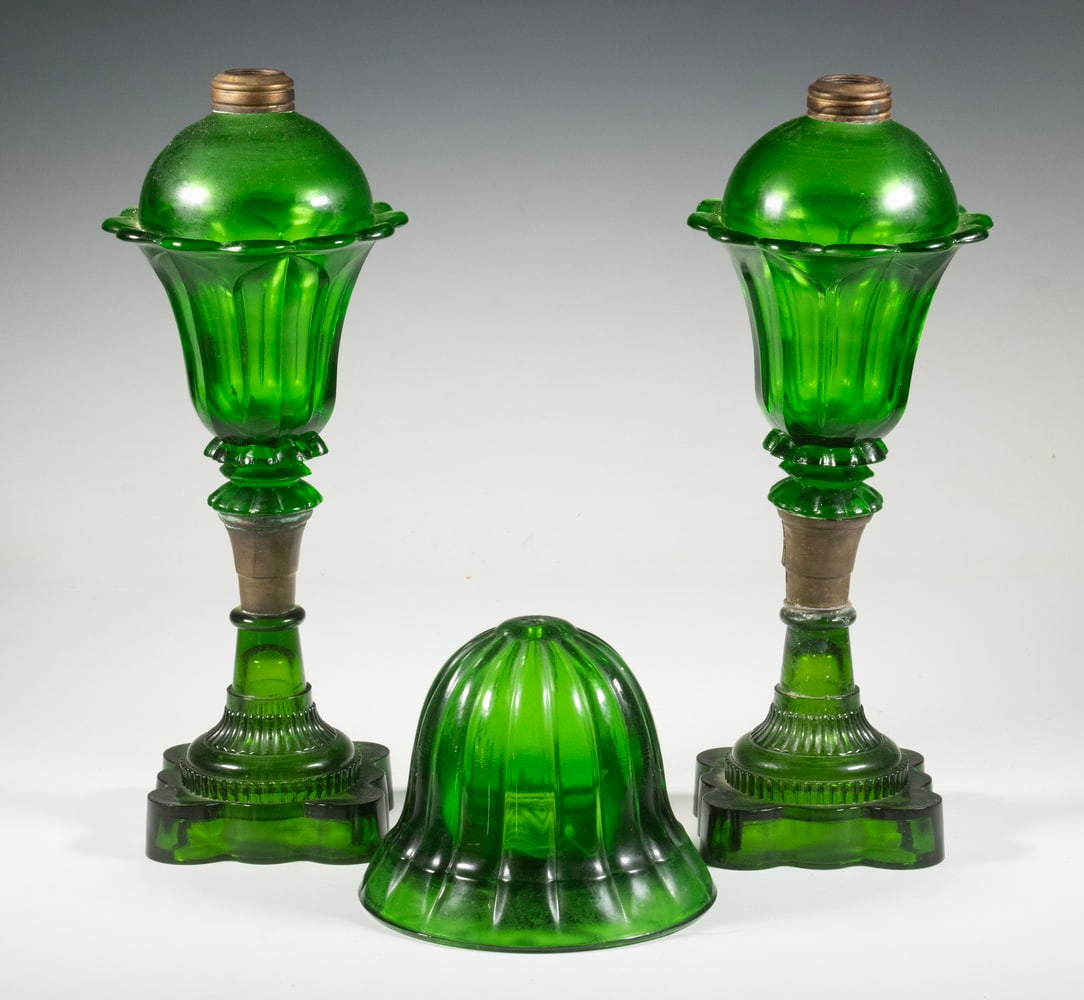 EMERALD GREEN GLASS OIL LAMPS & STRING HOLDER: (3) Piece Lot of Vintage Emerald Green Glass, incl: a pair of oil lamps, each in a tulip form design, set on a square scalloped base, 13" high, one with mid-body repair; and Bell shaped string holder,