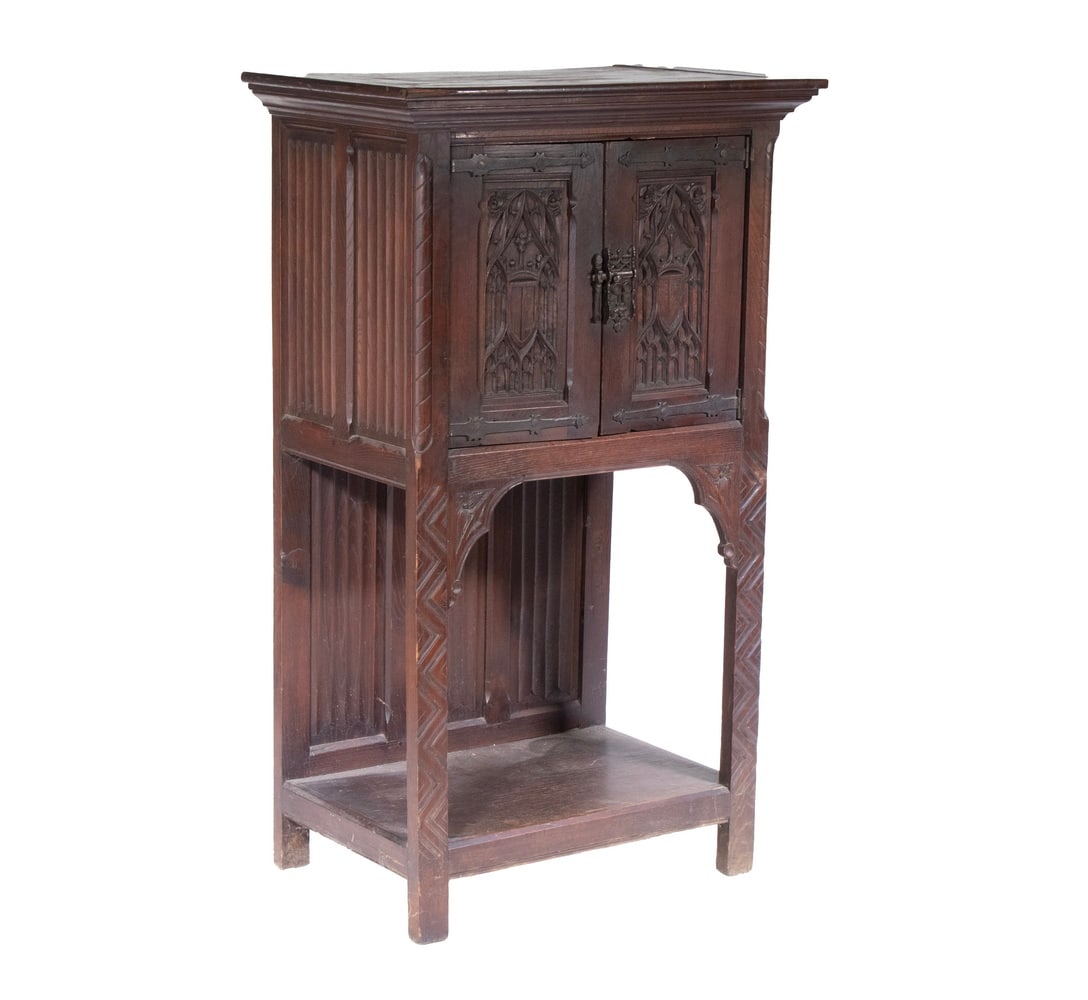 CIRCA 1900 ENGLISH OAK JACOBEAN CUPBOARD: Narrow Cupboard in dark oak, with deep flat molded cornice (having luan filler), over two tracery doors, raised on front columns with relief carved back panels, molded lower shelf. 51 1/2 x 30 x 20 in