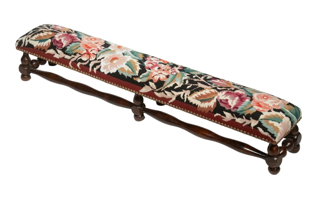 LONG LOW NEEDLEPOINT FOOT REST FOR TWO: Walnut Turned Foot Rest with floral needlepoint and brass tack upholstery. 7 1/2 x 42 x 7 in. (19.1 x 106.7 x 17.8 cm.)