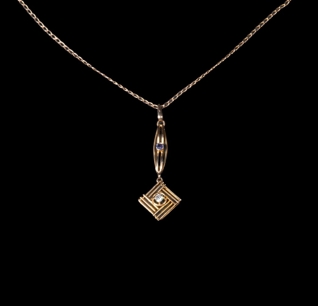 14K GOLD PENDANT WITH DIAMOND AND BLUE SPINEL ON 10K GOLD CHAIN: A geometric 14K yellow gold pendant centering a round-cut diamond within a square openwork frame, suspended from a linear connector accented by a small blue spinel. The pendant is fitted on a 10K yell