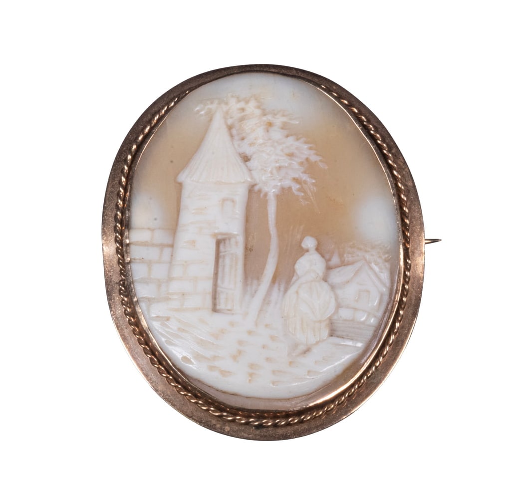 VICTORIAN ANTIQUE 14K GOLD SHELL CAMEO BROOCH: An oval shell cameo finely carved with a pastoral scene depicting a lady before a tower, mounted in a 14K yellow gold bezel with twisted rope border.