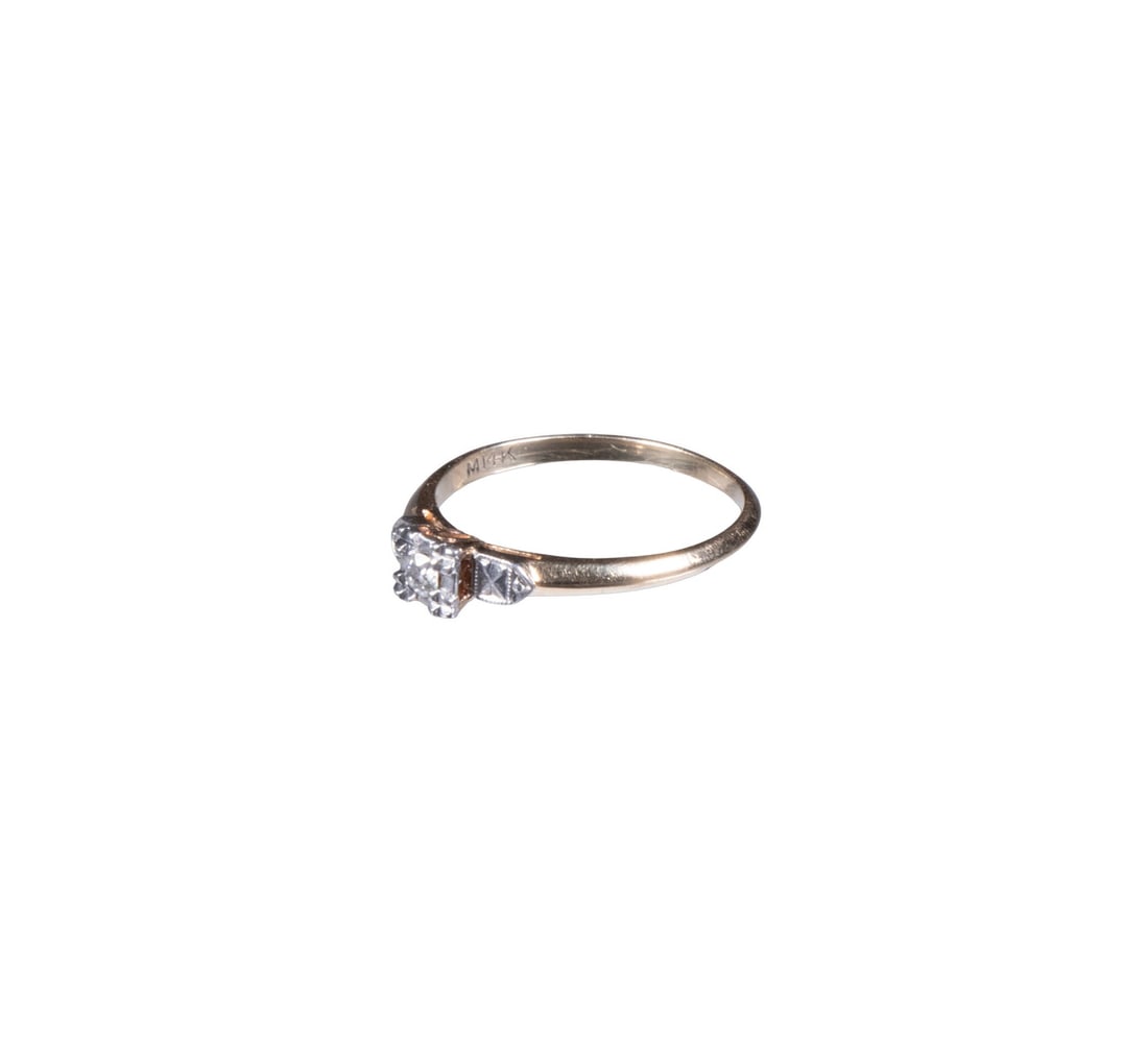 14K GOLD DIAMOND RING: A 14k gold diamond ring featuring a round brilliant-cut diamond of approximately 0.10 ct set in a white gold head. The shoulders with white gold decorative elements, transitioning into a plain yellow