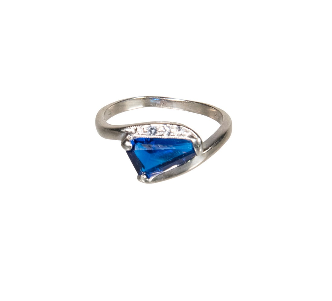 10K GOLD SPINEL AND AQUAMARINE RING: A 10K white gold ring centering a shield-cut blue spinel of vivid cobalt-blue color, accented by (3) small round aquamarines. 1.3 dwt. total weight. Ring size 6 1/4. Light wear consistent with use. Th