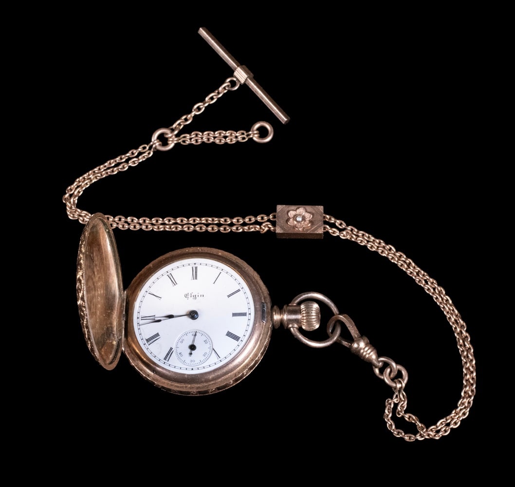 ELGIN 14K GOLD FILLED HUNTING CASE LADIES POCKET WATCH WITH CHAIN: An Elgin National Watch Co. gold filled hunting case lady's pocket watch, the round case finely engine-turned with repeating star motifs. White enamel dial with black Roman numerals and subsidiary