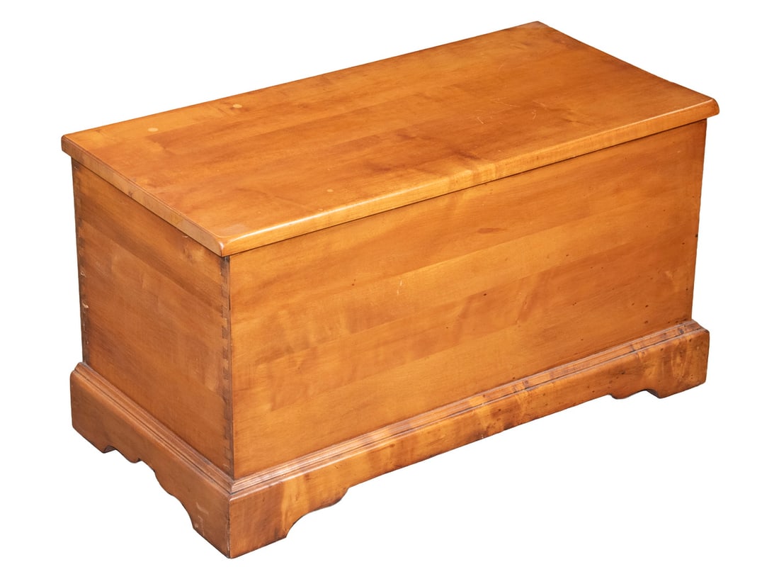 PIEDMONT MFG. CO. DIMINUTIVE MAPLE STORAGE CHEST: Custom Chippendale Style Lift Top Trunk, with exposed dovetailed corners, hinged lid, interior marked "Solid Maple, Piedmont Mfg. Co.", with shaped bracket base, set on casters.16 x 29 x 14 in. (40.6