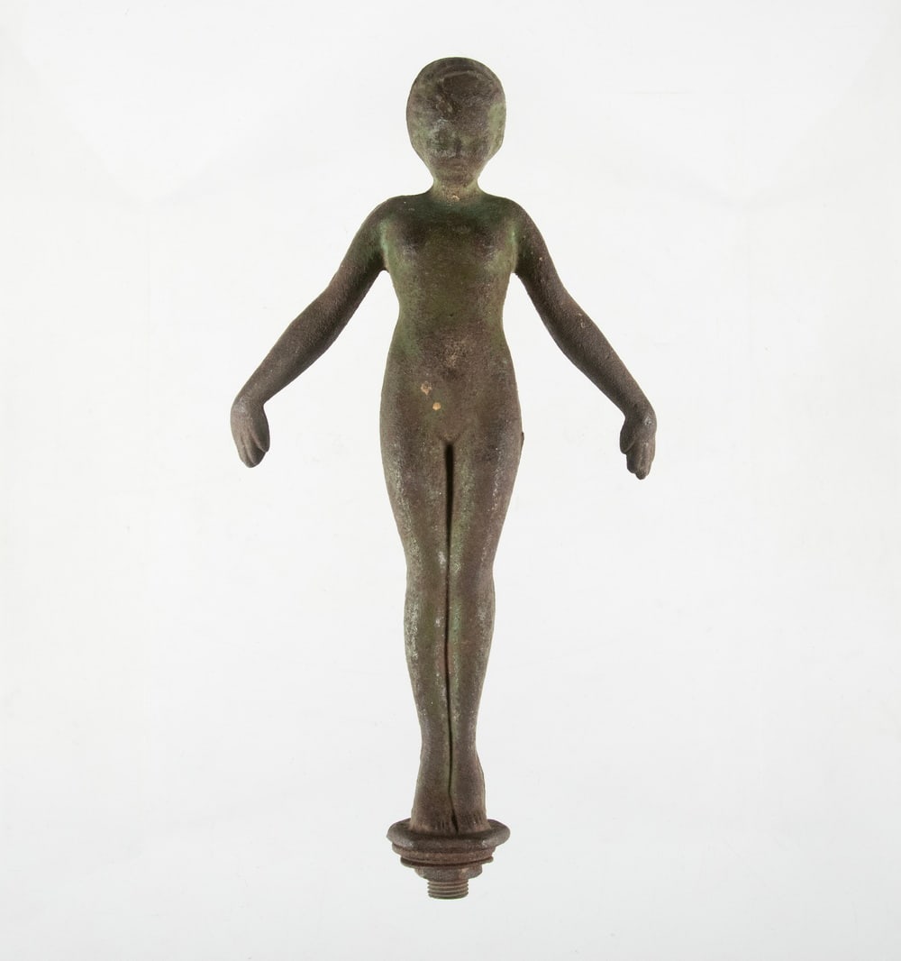 SMALL CAST IRON FIGURAL FOUNTAIN CREST, PROBABLY JW FISKE: Standing Sea Nymph, in cast iron with remnants of faux verdigris finish, bolt on base.Overall Height: 8 in. (20.3 cm.)