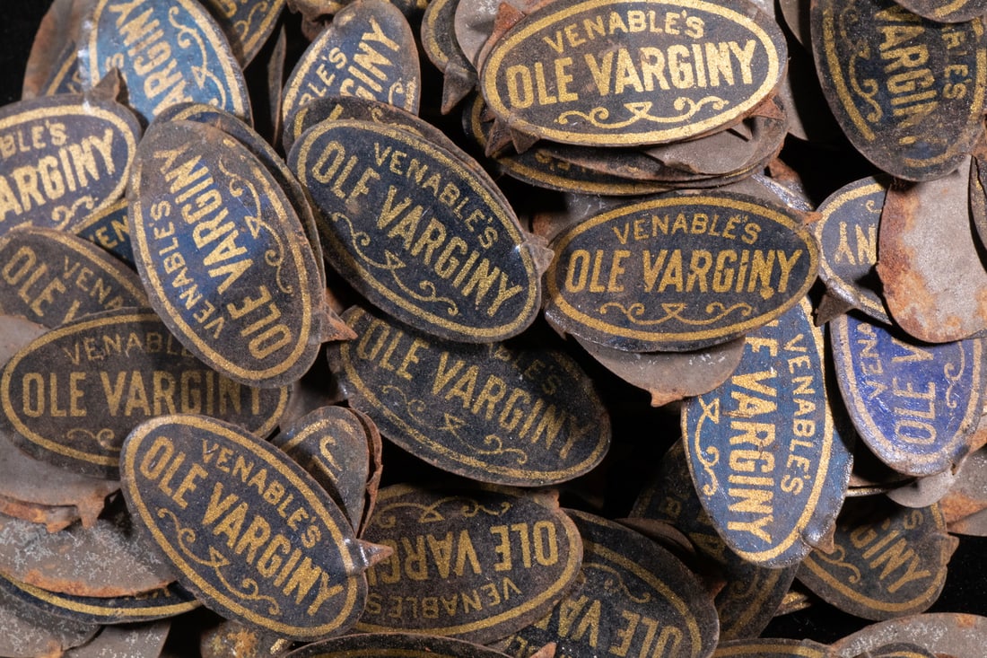 (229) ANTIQUE TIN TOBACCO TAGS, “VENABLE’S OLE VARGINY”: A large group of 229 pressed tin tobacco tags, oval form with a black ground exhibiting deep-blue iridescent highlights, the brand name in gilt lettering reading “VENABLE’S OLE