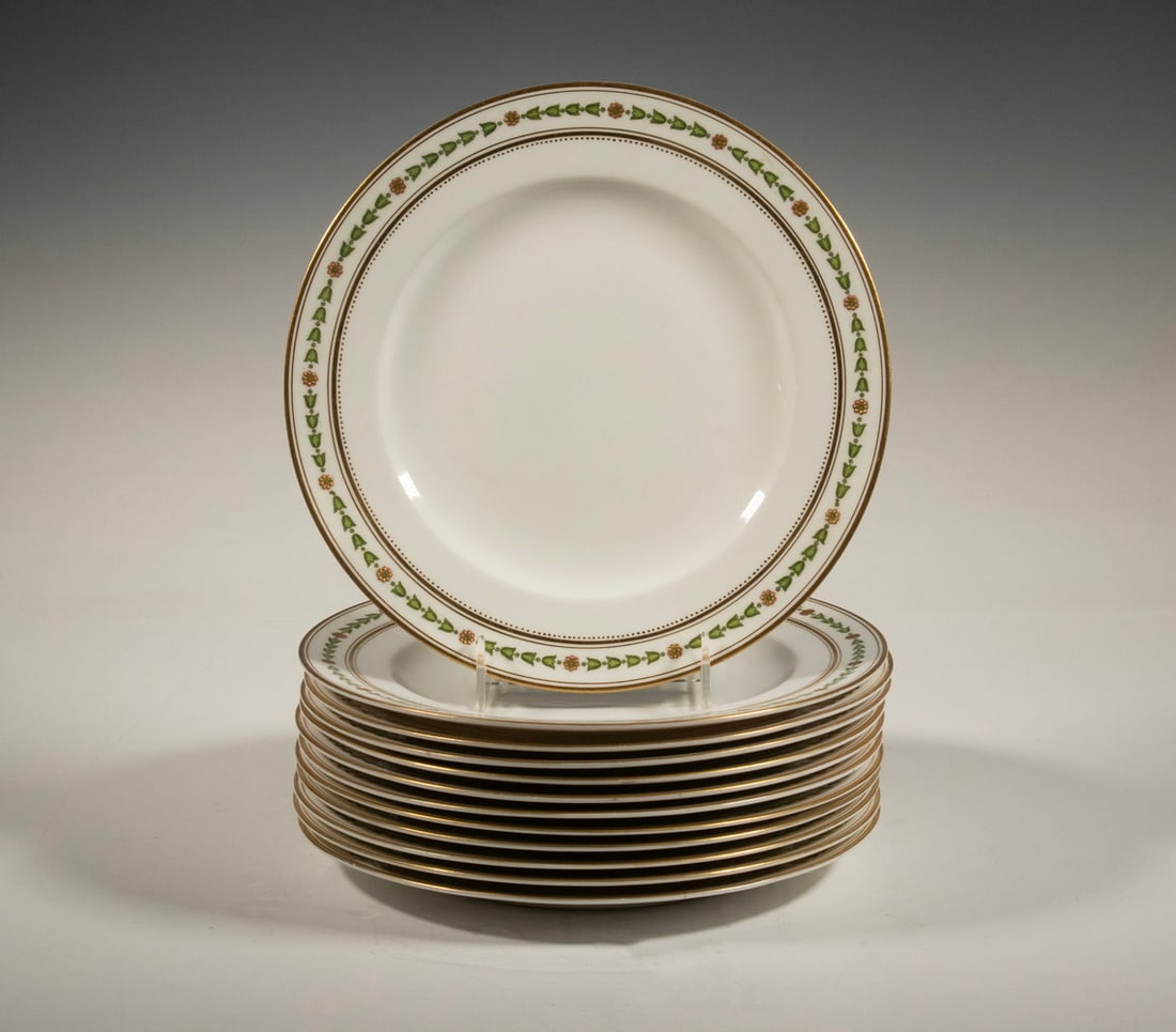 (12) GEORGE JONES & SONS “CRESCENT” DINNER PLATE, ENGLAND: Each with a neoclassical border of green and yellow flowers, framed by gilt accents. Made by George Jones & Sons under the Crescent China line, marked.0 7/8 x 10 x 10 in. (2.2 x 25.4 x 25.4 cm.)