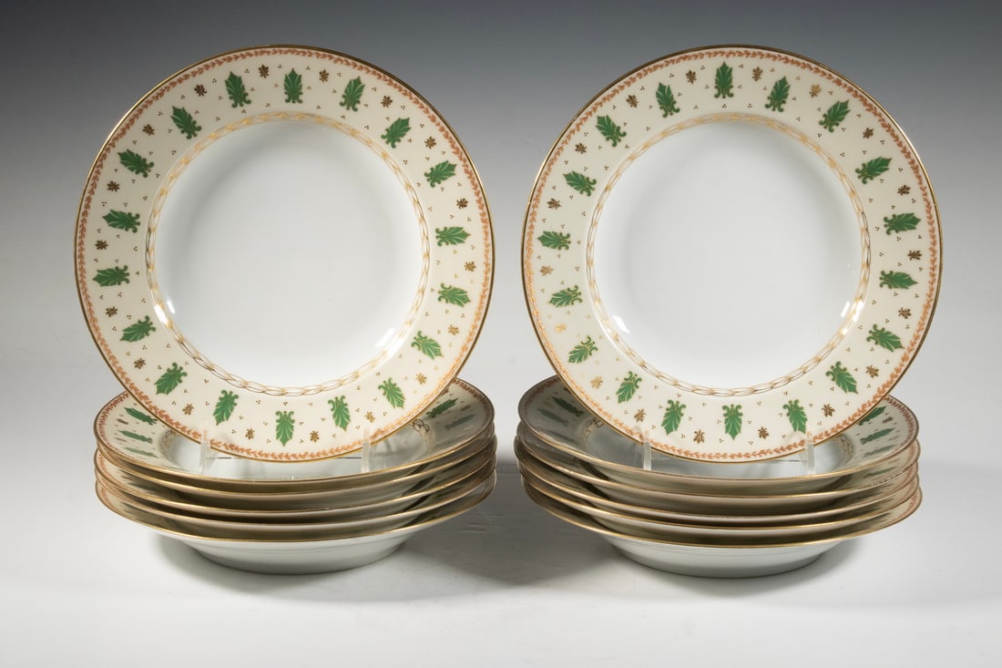 (12) FRENCH CHARLES AHRENFELDT LIMOGES PORCELAIN RIMMED SOUP BOWLS: Each features a stylized green foliate motif and a braided gilt inner border, with a gilded vine rim and scattered gilt accents. Marked C.A. France and R.B. Boston, Fabrique en France.Size: ea. 1 3/4