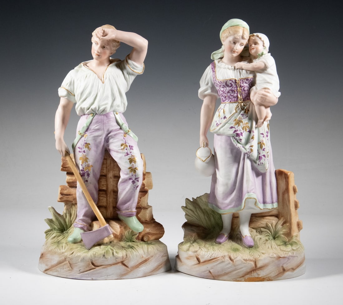 PR GEBRUDER HEUBACH BISQUE PORELAIN FIGURES: Pair of Early 20th c. German Porcelain Standing Figurines, depicting a wood cutter holding an ax and a woman holding a child, with raised maker's mark at the back edge.LGST Height: 15 in. (38.1 cm.),