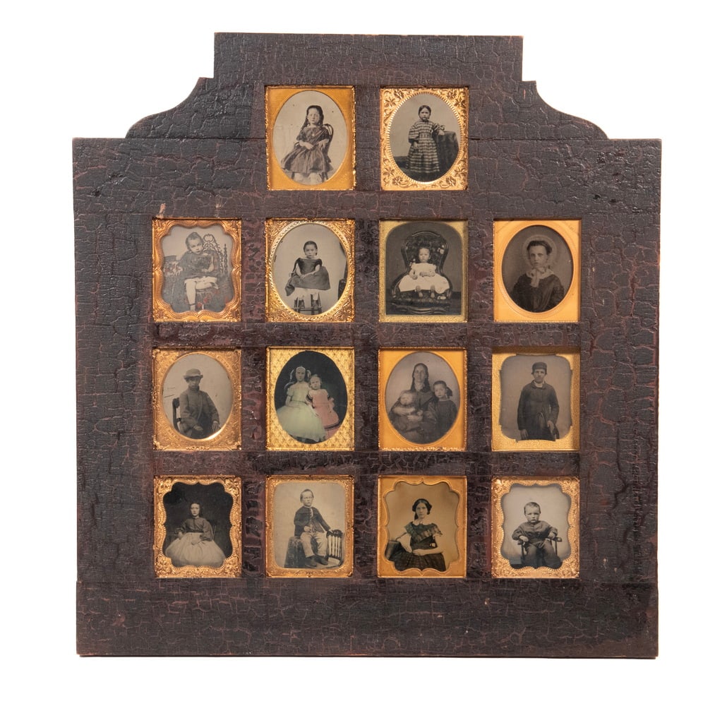 (14) EARLY TINTYPES OF CHILDREN IN ONE VINTAGE FRAME CIRCA 1855-70: Mostly Little Girls in their best chintz dresses, one with nice ruffled bonnet, the two oldest boys are in work clothes, the frame is pine in original crackled black paint.OS: 16 1/2 x 17 1/2 in.