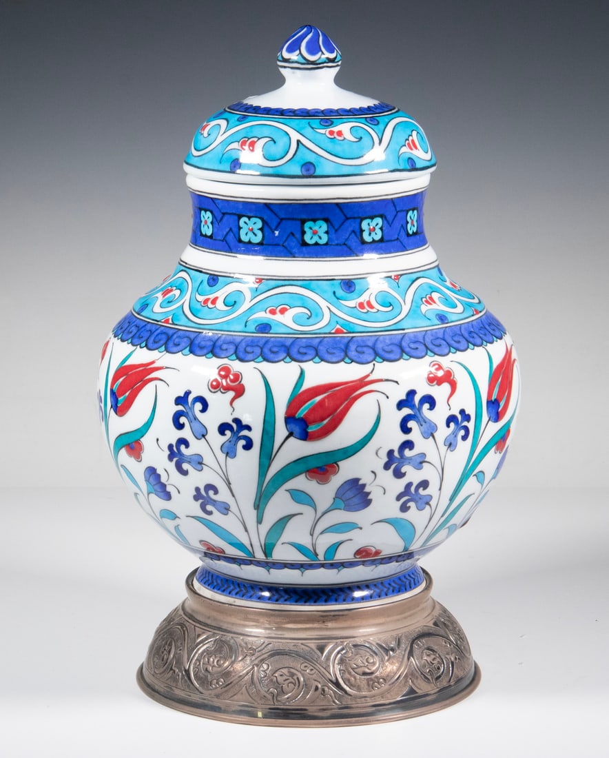 IZNIK DESIGN LIDDED JAR BY ADNAN HOCA ERGULER: Turkish Glazed Pottery Covered Jar on silver-plated metal base, with tulips and hyacinth decoration inspired by 16th c. Iznik motifs, by master ceramic artist Adnan Hoca Erguler (d. 2016), retailed