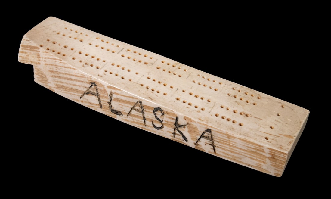 ALASKA WALRUS IVORY CRIBBAGE BOARD: Solid Tusk Fragment, with raw edge marked "Alaska".9 x 2 1/4 x 3/4 in. (22.9 x 5.7 x 1.9 cm.)