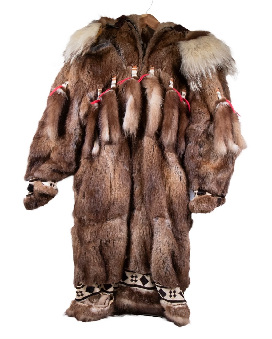 20TH C. INUIT PARKA, MAN'S SIZE: Aklavick style parka, Alaskan Inuit, in various furs that typically include caribou, seal, wolf and wolverine, having geometric bands called qupak, lined with synthetic fur. Tab and tail with red yarn