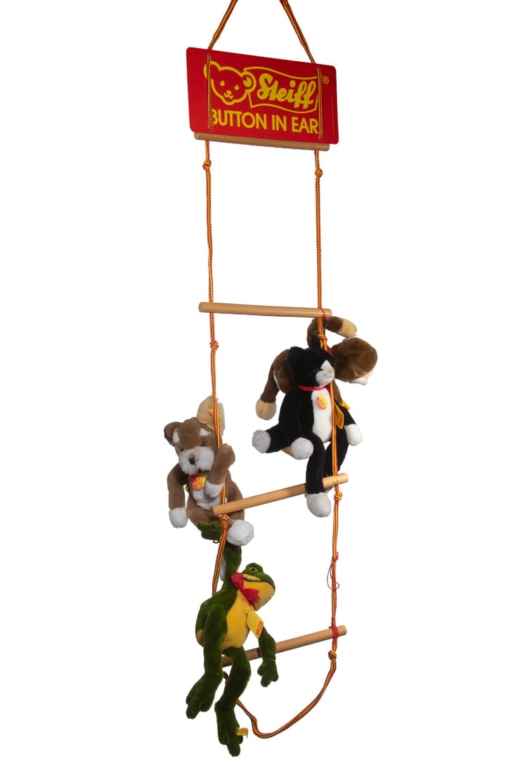 STEIFF PLUSH ANIMALS ON ORIGINAL DISPLAY LADDER: A Steiff retail display set featuring four plush animals—frog, dog, cat, and monkey—each with original yellow ear button, yellow chest tag, and paper hang tag, mounted on the original wood