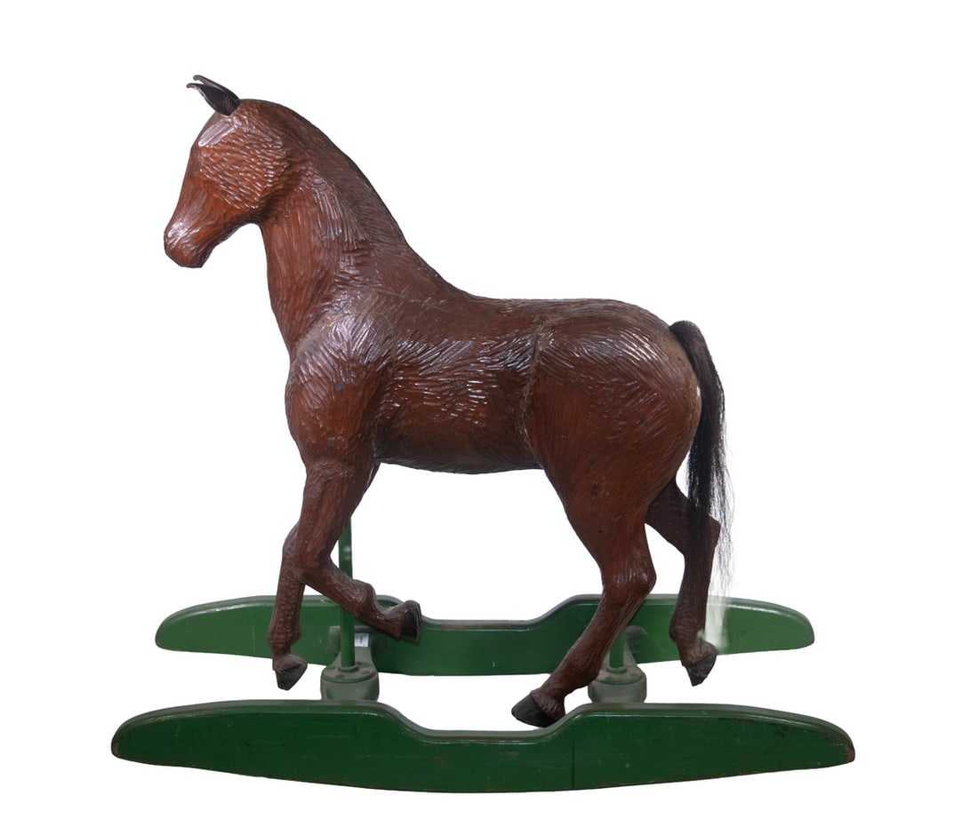 VINTAGE CARVED WOODEN ROCKING HORSE: Circa 1920s Child's Riding Toy, depicting a carved wooden horse with leather ears and horsehair tail, attached to two cylindrical metal poles and mounted on a painted wooden rocker base. Shrinkage cra