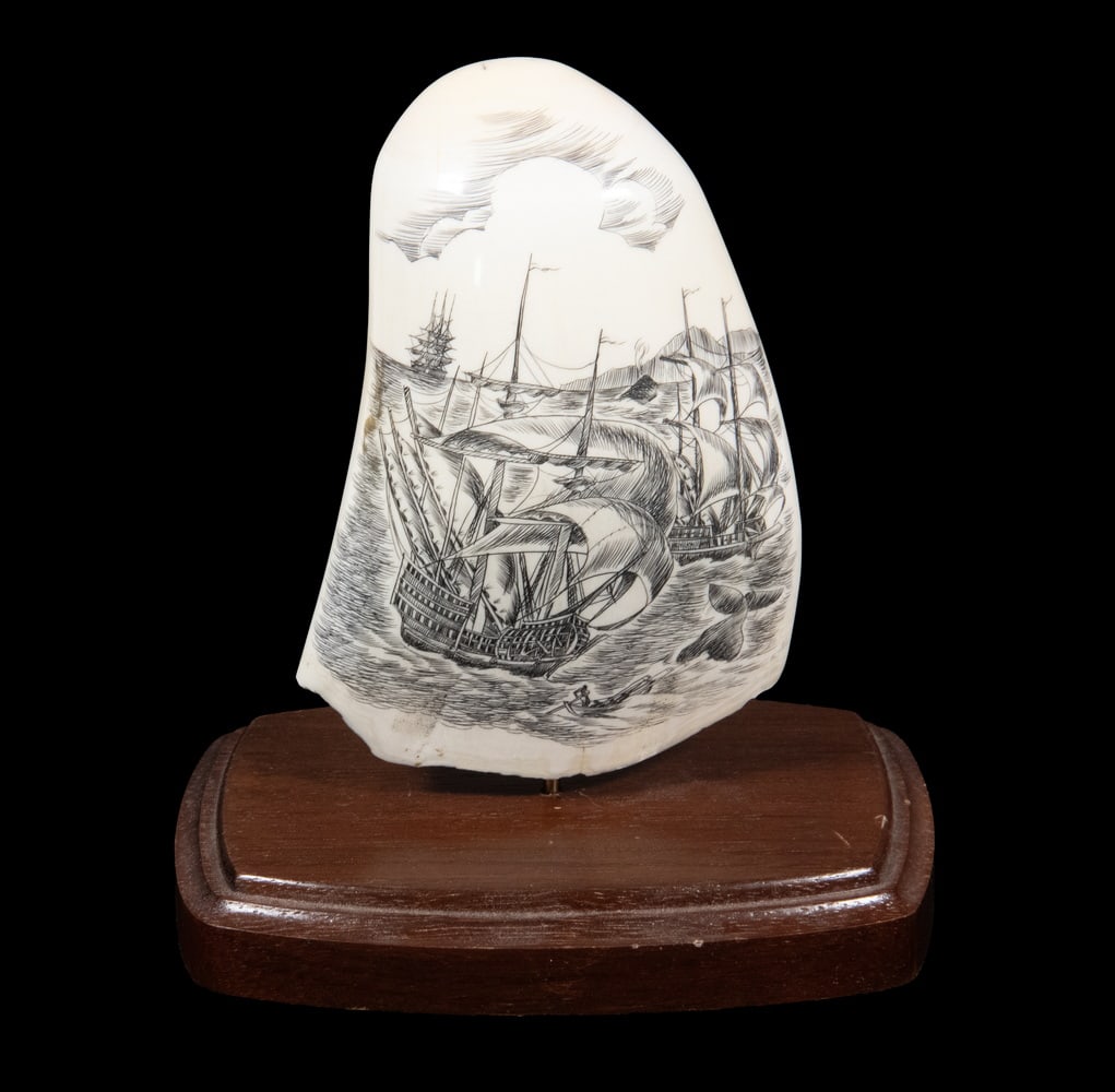 LARGE SCRIMSHAWN WHALE'S TOOTH, WHALING, 2-SIDED: One side with three ships, boat and whale; the other with single ship, boat and whale, vertical. 14.5 oz; includes stand.Size: 5 in. (12.7 cm.)