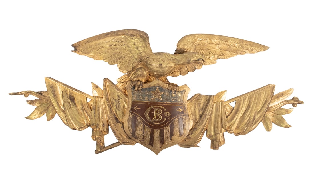 CIVIL WAR ERA 'B CO.' EAGLE PLAQUE: Parade Banner Crest in carved and painted wood with gilding, consisting of a spread wing eagle surmounting a shield marked with "Co. B" at center, over crossed weapons and draped flags and laurel leav