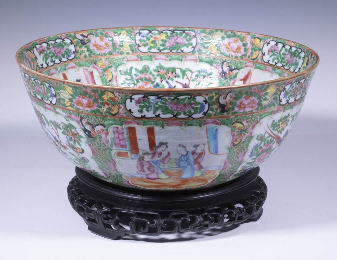 CHINESE EXPORT PORCELAIN PUNCH BOWL: 19th c. Rose Medallion Porcelain Bowl, having panels containing figural, floral, and bird decoration amidst a floral and butterfly-covered background, on a carved and reticulated wooden stand, bowl