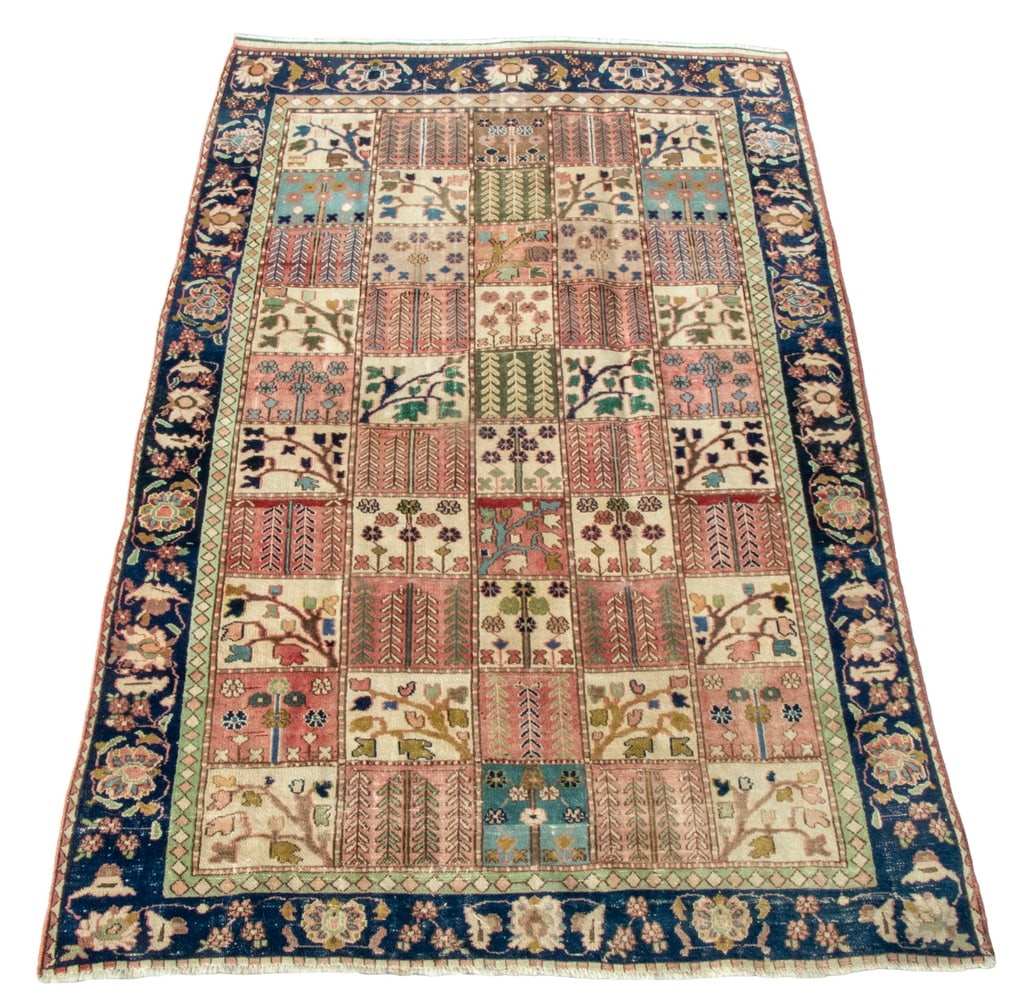 BAHKTIARI CARPET (5'11" X 9'6"): Made in West Persia in the first quarter of the 20th Century. Features a square grid of rosettes, flowering vines, and trees in midnight blue, sky blue, ivory, terra-cotta, blue-green and gold with a