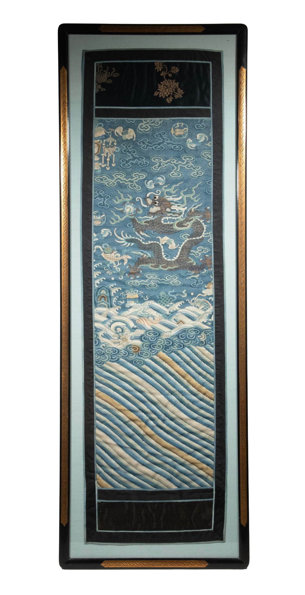 CHINESE KESI SILK PANEL WITH DRAGON AND BUDDHIST EIGHT TREASURES, 19TH CENTURY: A finely woven Chinese kesi silk panel depicting a five-clawed dragon emerging amid stylized waves and scrolling clouds, grasping a flaming pearl. The surrounding field incorporates auspicious Buddhis