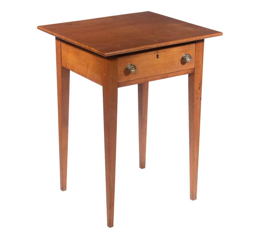 FEDERAL PERIOD COUNTRY HEPPLEWHITE CHERRY STAND: Single Drawer Stand with thin overhanding top, deep skirt, drawer having two pressed brass hollow knobs, pine secondary, raised on slender tapered square legs. 28 x 21 1/2 x 19 in. (71.1 x 54.6 x 48.3