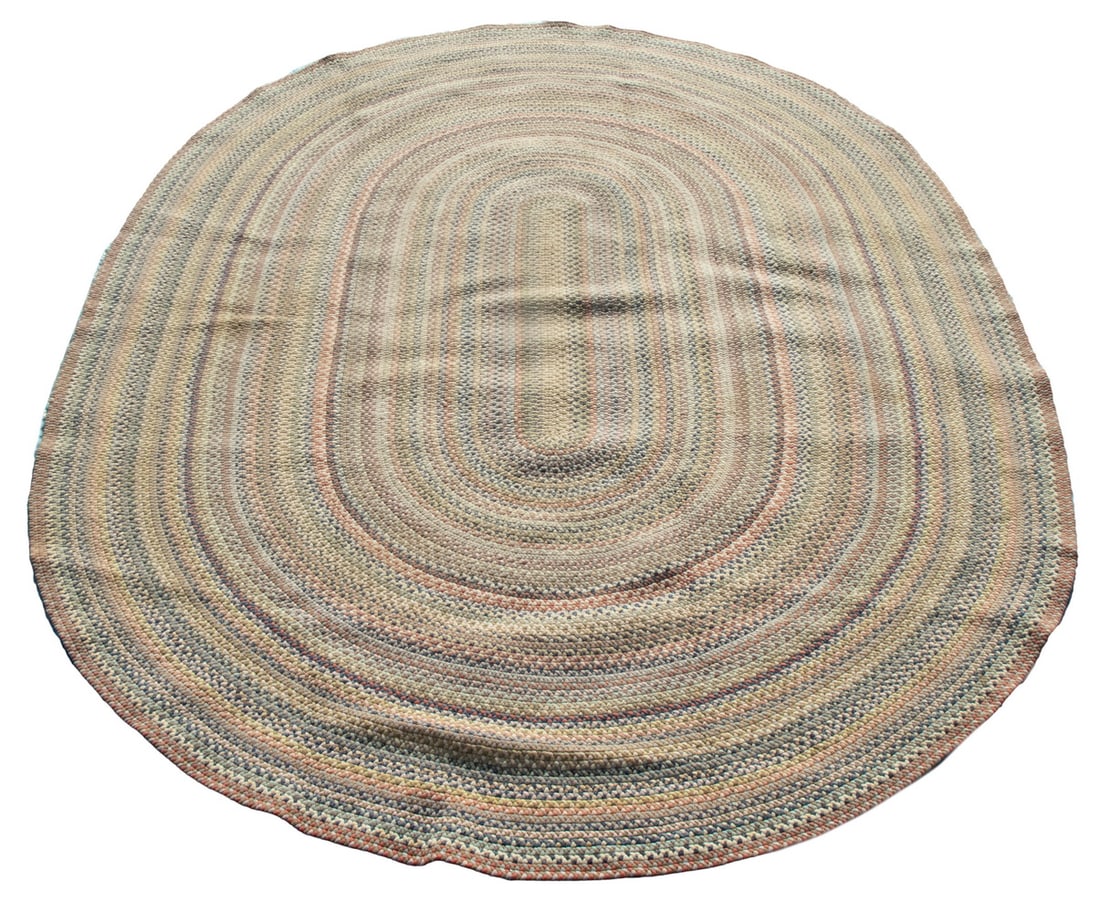 OVAL ROOM SIZE BRAIDED CARPET (8' x 13'): A rustic carpet featuring concentric bands in navy and sky blue, tan, brick, gray and ivory. Overall good condition with some light staining.From the estate of Linda Bean.OS: 96 x 156 in. (243.8 x
