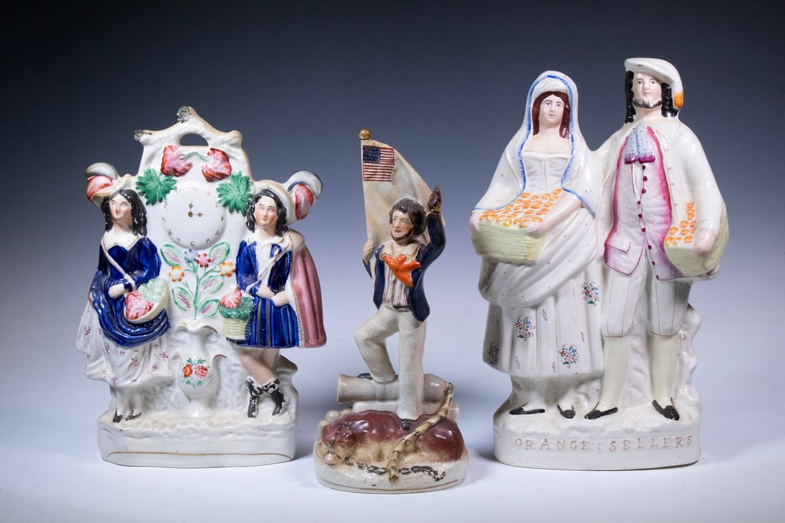 (3) 19TH C. STAFFORDSHIRE FIGURINES: Group of English Glazed Earthenware Figures, incl: "Orange Sellers" flatback, 13 1/2" high, 7 1/2" x 3 1/2"; Flatback depicting a standing couple and painted strawberry decoration, 12 1/2" high, 9" x