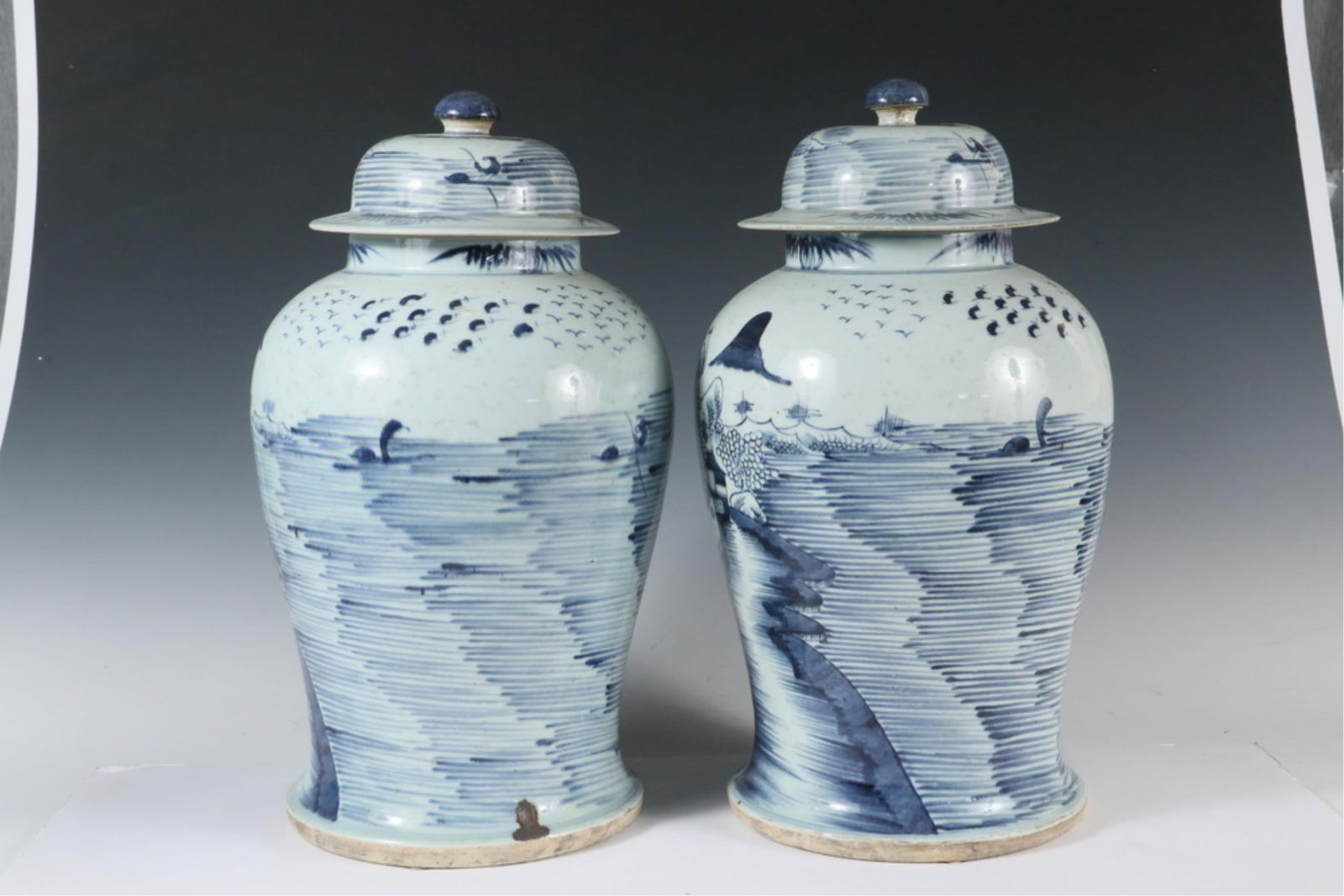 PR OF CHINESE EXPORT COVERED TEMPLE JARS: Late 19th to early 20th c. Canton Blue and White Tall Temple Jars with domed and flanged lids having semispherical knobs, wraparound mountain lake landscape with buildings, figures and boats, full