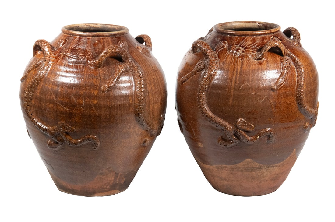PR CHINESE BROWN-GLAZED STONEWARE DRAGON STORAGE JARS: A pair of Chinese stoneware storage jars, each of globular form body with molded in relief with sinuous dragons amid cloud motifs. The vessels are covered in a rich brown glaze with darker pooling