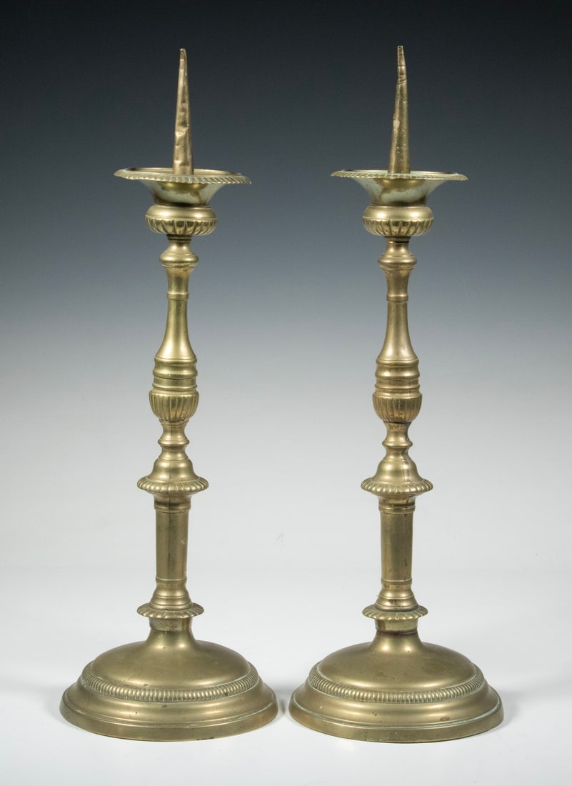 PAIR OF 19TH C. BRASS ALTAR PRICKET CANDLESTANDS: Italian style, with reeded baluster stems on domed base, Greek urn form wax catcher, long spike.Size: 18 x 6 x 6 in. (45.7 x 15.2 x 15.2 cm.)