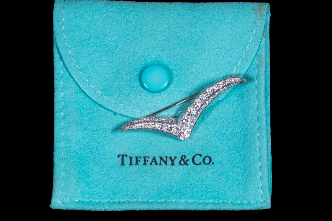 TIFFANY & CO. PLATINUM AND DIAMOND “SEAGULL” BROOCH: A stylized “Seagull” or chevron-form brooch by Tiffany & Co., pavé-set with approximately (42) round brilliant and single-cut diamonds, the largest measuring about 3.5 mm (approx. 0.1