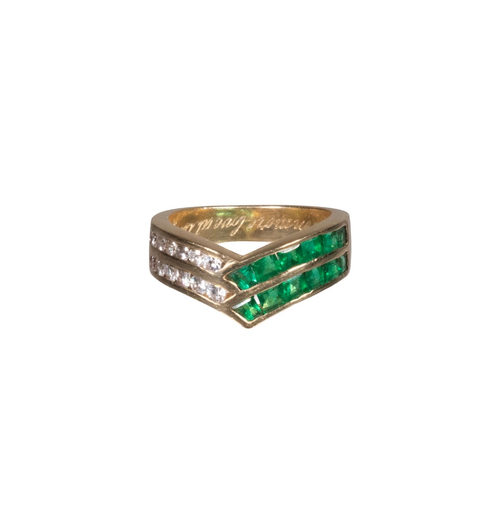 18K YELLOW GOLD EMERALD AND DIAMOND RING: An 18K yellow gold ring set with two rows of (12) calibre-cut emeralds following the sweeping curve of the band, accented by two parallel rows of (12) round brilliant-cut diamonds. Interior stamped