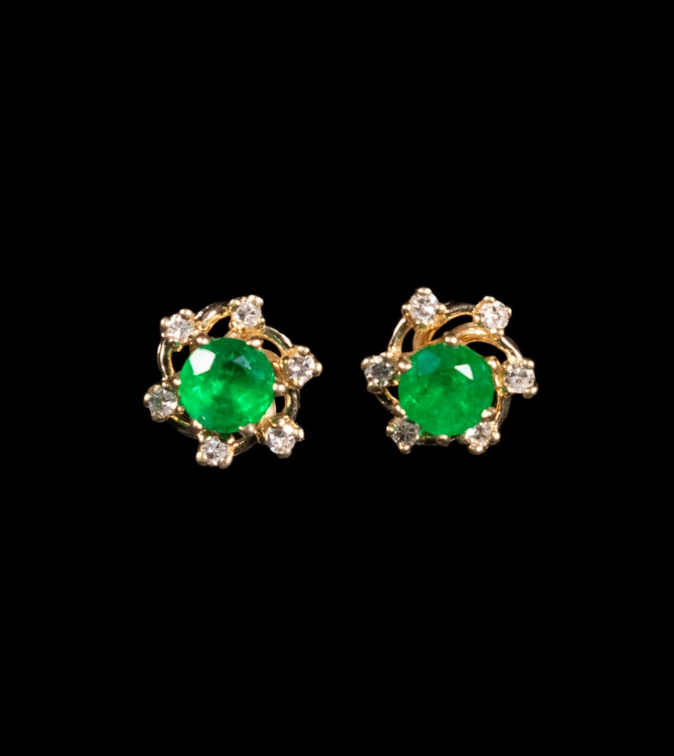 PR 14K GOLD EMERALD AND DIAMOND STUD EARRINGS WITH REMOVABLE JACKETS: A pair of 14K yellow gold stud earrings set with (2) round faceted emeralds, each approximately 0.50 ct, in six-prong mounts. Accompanied by removable diamond “flower” jackets, each set wi