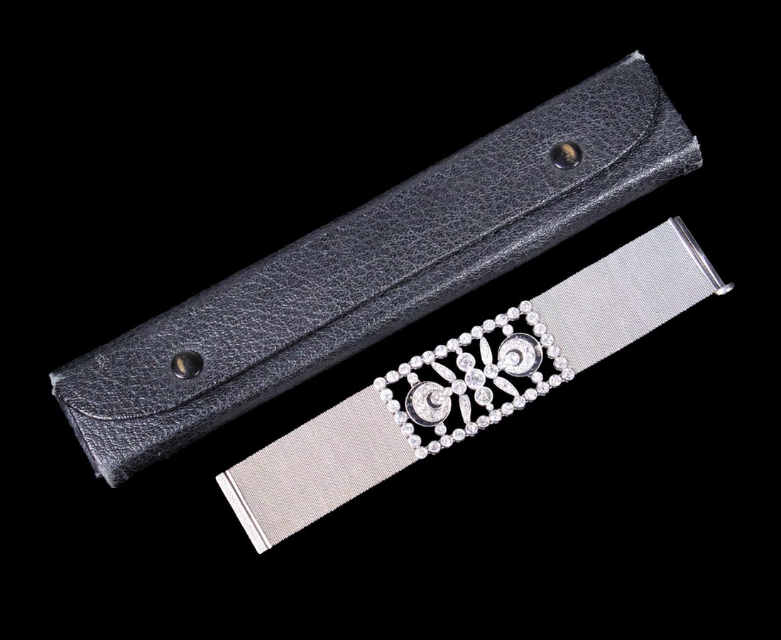 ART DECO PLATINUM, DIAMOND AND ONYX BRACELET WITH ORIGINAL CASE: An exceptional platinum bracelet centering a geometric openwork panel set with approximately (85) old European and single-cut diamonds, the largest measuring about 6 mm in diameter, accented by facete