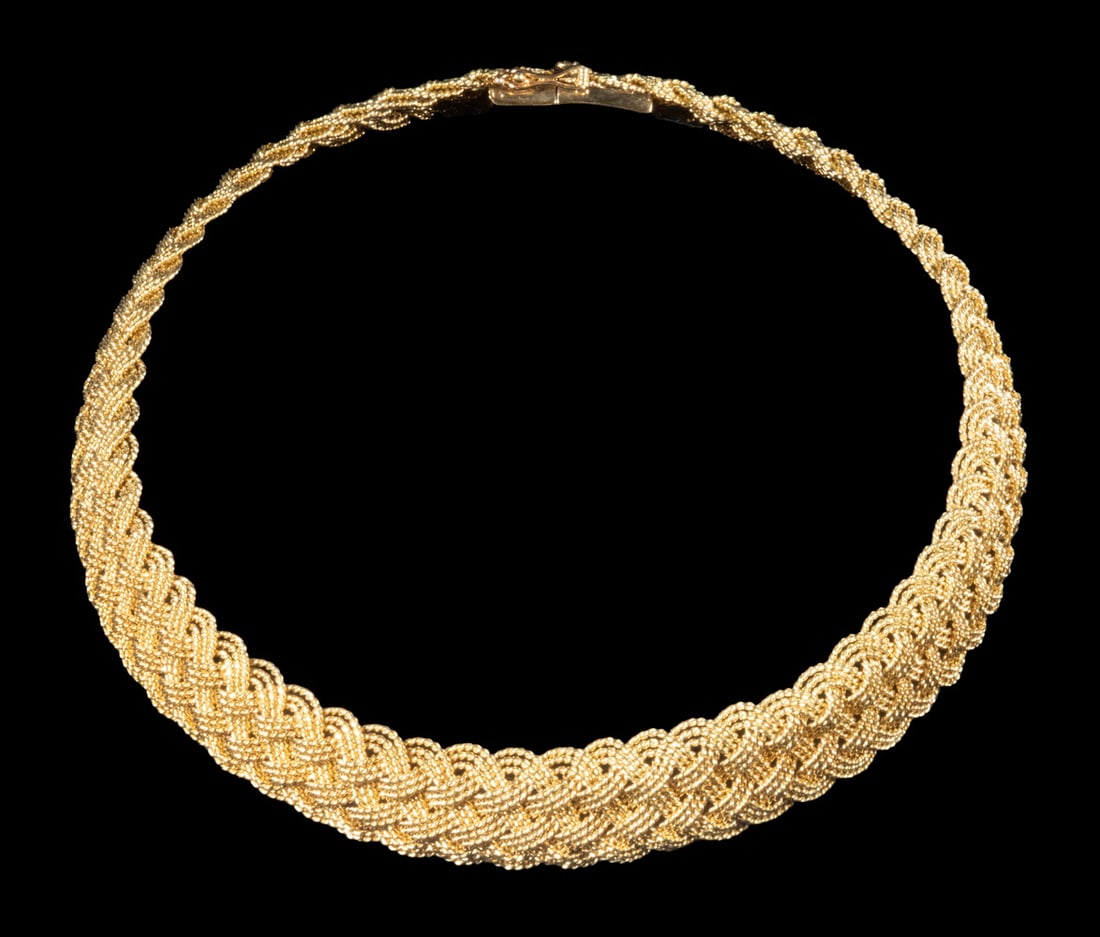 A.G.A. CORREA & SON HEAVY 18K GOLD HAND-WOVEN BRAIDED COLLAR: A finely hand-woven 18K yellow gold collar necklace by A.G.A. Correa & Son, composed of three interlaced strands forming a wide braided mesh pattern. The clasp stamped “18K” and “AGA