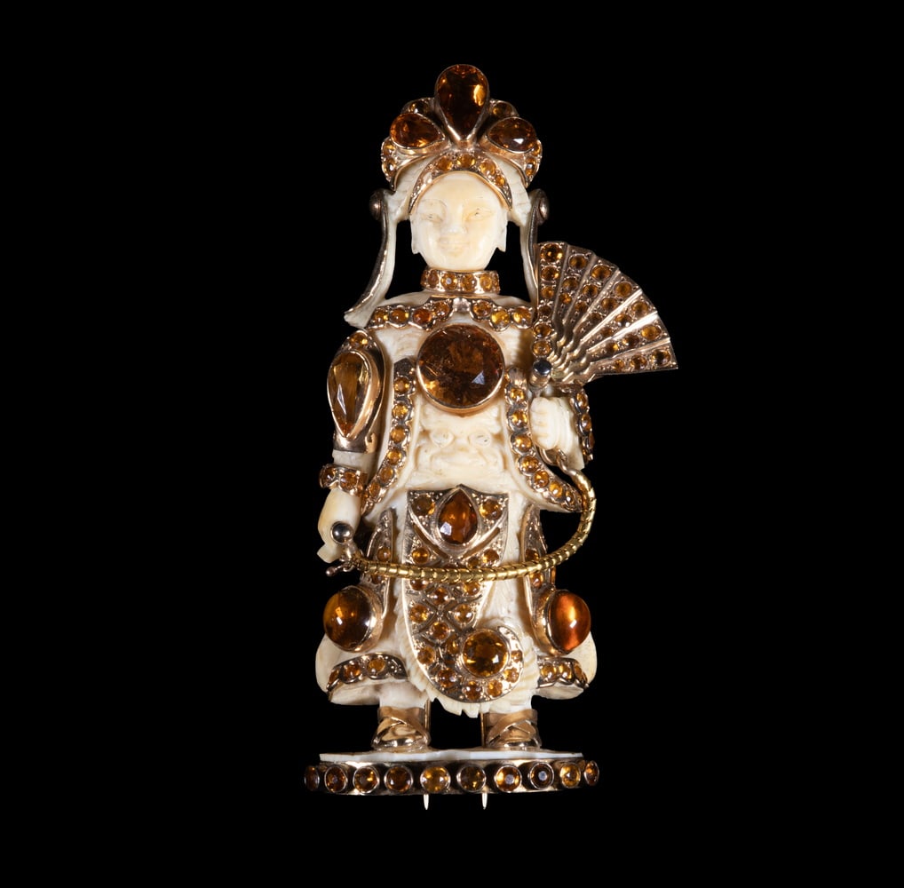 FULCO DI VERDURA 14K GOLD, CITRINE & IVORY FIGURAL BROOCH, C. 1930S: A finely detailed standing figure brooch, the carved ivory body mounted in 14K yellow gold and richly set with citrines of various shapes and sizes. The figure holds a fan and wears a headdress and or